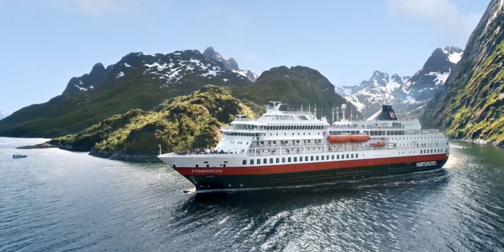 Hurtigruten coastal ship sailing through a Norwegian fjord
