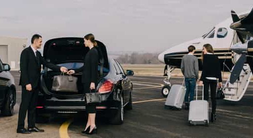 Chauffeur loading luggage beside a private jet on the tarmac
