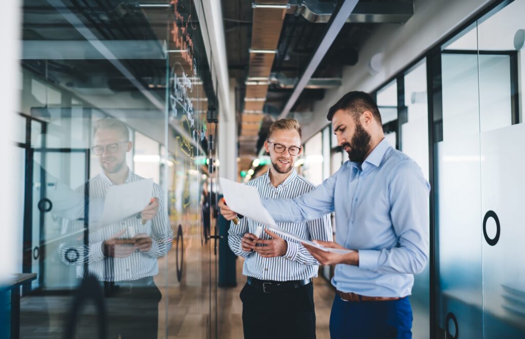 Business consultants reviewing documents in a modern glass office