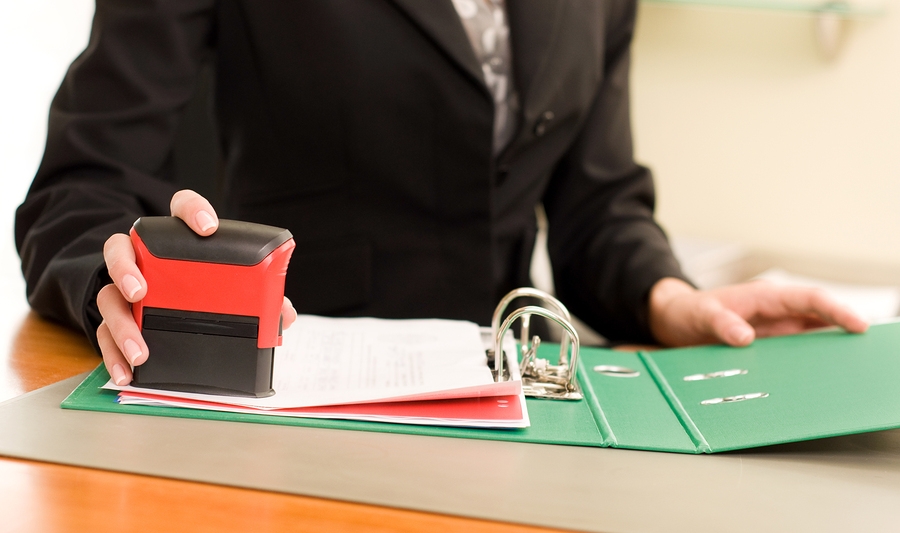 Hand stamping documents with a red self-inking stamp
