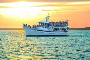 Sightseeing boat full of passengers sailing at sunset