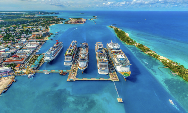 Aerial view of cruise ships docked at a Caribbean port surrounded by turquoise water