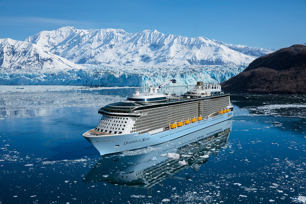 Ovation of the Seas cruise ship sailing near snowy mountains in Alaska