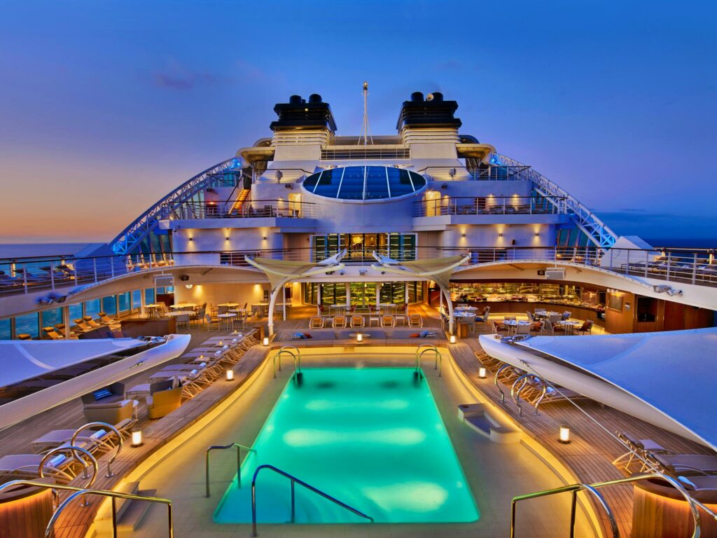 Pool deck of the Seabourn Encore cruise ship lit up at twilight