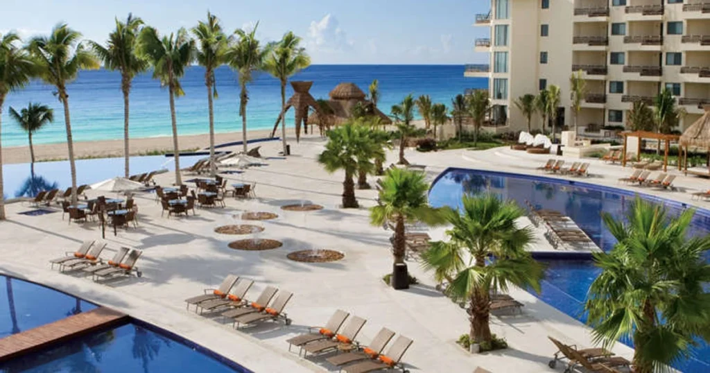 Beachfront all-inclusive resort with pools, palm trees and lounge chairs